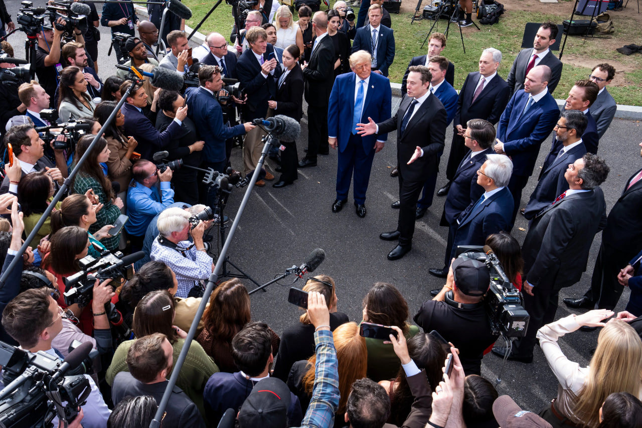 Elon Musk and Donald Trump surrounded by reporters
